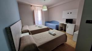 a small room with two beds and a blue chair at Hotel Santamaria in Villa Santa Maria