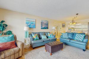 a living room with two couches and a table at Edgewater West 45 in Gulf Shores