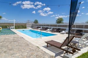 a swimming pool with a bench and a table and chairs at Casa Mariana in Murighiol