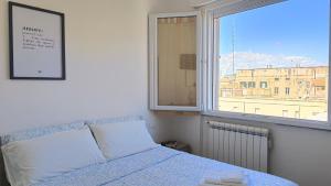 ein Schlafzimmer mit einem Bett und einem großen Fenster in der Unterkunft Rossana Apartment in Pescara