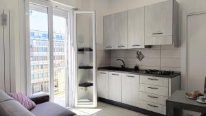 eine Küche mit weißen Schränken und einem großen Fenster in der Unterkunft Rossana Apartment in Pescara