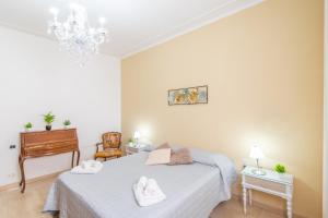 ピオンビーノにあるPiombino Apartments Casa Amendolaの白いタオルが敷かれたベッドのある寝室