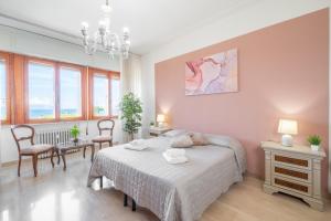 ピオンビーノにあるPiombino Apartments Casa Amendolaのベッドルーム1室(ベッド1台、椅子2脚、窓付)