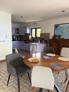 eine Küche und ein Esszimmer mit einem Holztisch und Stühlen in der Unterkunft Villa Orea Elena-Mani-Kalamata in Verga Kalamata