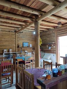 a dining room with a table and chairs in a cabin at Pousada Recanto da Pantera in Cunha