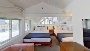 two beds in a room with windows and a couch at Crestwood 1301 Premier 1 Bedroom plus Loft in Snowmass Village