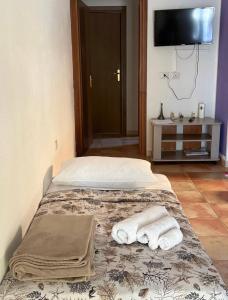 two beds in a room with a tv and towels at Dream House in San Giovanni Suergiu
