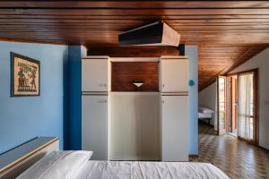 a room with a white refrigerator and a wooden ceiling at Alloggio vista mare in San Bartolomeo al Mare