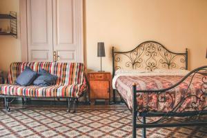 a bedroom with a bed and a couch and a chair at Casa Verdi - House of Travelers in Catania +36 photos