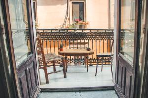 a table and two chairs on a balcony at Casa Verdi - House of Travelers in Catania