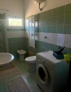 a bathroom with a washing machine and a toilet at Dream House in San Giovanni Suergiu