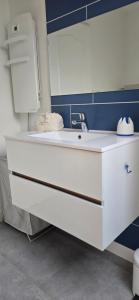 a bathroom with a white sink and a blue wall at La Re Source Chambre et table d'hôtes in Villers-le-Lac