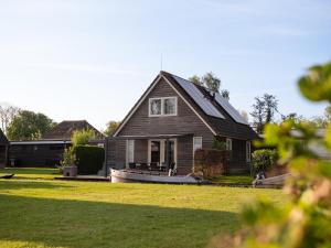 a house with a boat in the front yard at De Sloothaak in Giethoorn