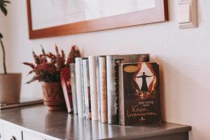 a row of books sitting on a table at Røvær Havhotell in Røvær
