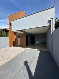 a shadow of a person taking a picture of a house at Casa confortavel e aconchegante in Sinop
