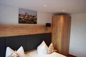 a bedroom with a bed with a wooden headboard at Hotel Am Siebersturm in Rothenburg ob der Tauber