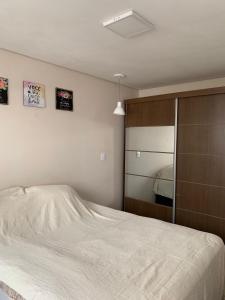 a bedroom with a bed and a large mirror at Charmoso AP VOG VILLE Caruaru in Caruaru