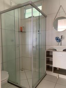 a glass shower in a bathroom with a sink at Charmoso AP VOG VILLE Caruaru in Caruaru