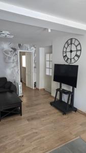 a living room with a clock on the wall and a piano at Maison in Oucques
