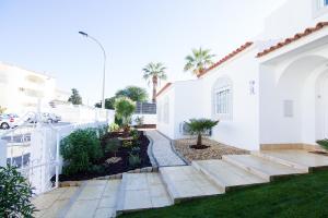 a white house with a courtyard with palm trees at Akivillas Albufeira Aqua V in Albufeira