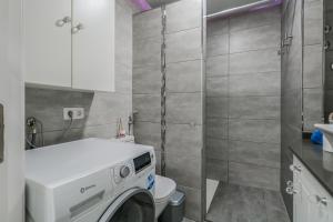 a small bathroom with a washing machine in it at Puerto Cruz Relaxing Shared Pool in Puerto de la Cruz
