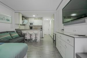 a living room with a couch and a kitchen at Puerto Cruz Relaxing Shared Pool in Puerto de la Cruz +6 photos
