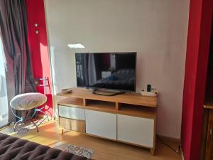 a living room with a television on a wooden entertainment center at Luz Urbana BA Studio in Buenos Aires