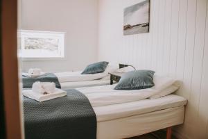 three beds are lined up in a room at Røvær Havhotell in Røvær
