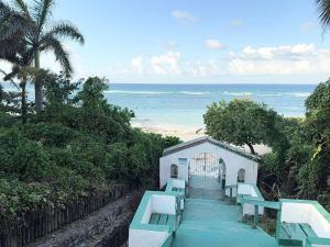 een klein gebouw met blauwe banken op het strand bij Seacastle Beach Penthouse in Montego Bay