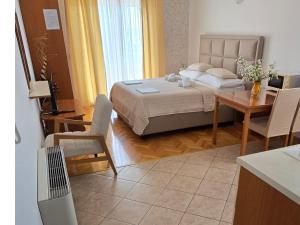 a bedroom with a bed and a table and a kitchen at Apartments Villa Katarina in Makarska