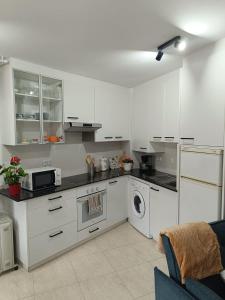 a kitchen with white cabinets and a washing machine at Estudio Centro A Guarda in A Guarda