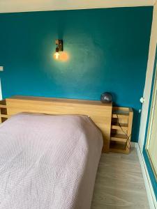 a bedroom with a bed and a blue wall at Les Meublés de la Corniche in Argelès-sur-Mer