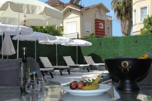 a table with a bowl of fruit and a bottle of wine at Villa De Papel in Belek