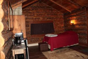 a bedroom with a red bed in a brick wall at Family Cabin Rental on Beautiful Ranch near Yellowstone National Park, Wyoming in Wapiti