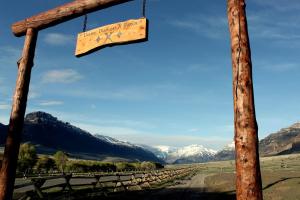 a sign for a vineyard with mountains in the background at Family Cabin Rental on Beautiful Ranch near Yellowstone National Park, Wyoming in Wapiti
