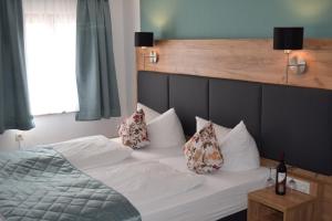 Un dormitorio con una cama blanca con almohadas. en Hotel Am Siebersturm en Rothenburg ob der Tauber