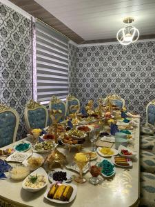 a long table with plates of food on it at Omurbek Guesthouse in Sary-Mogul