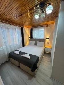 a bedroom with a large bed and two windows at Ali's Pension ada alis in Egirdir