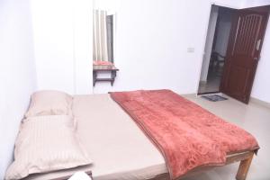 a bed with a red blanket on it in a room at Sai Comforts in Jāmb
