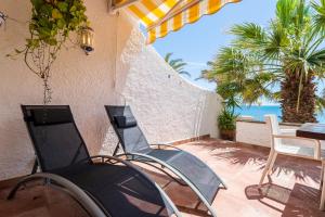 a patio with chairs and a table and the ocean at Hauzify I Casa Mirador 8 in L'Ametlla de Mar