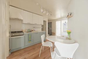 ソウルにあるSeoul Sensibility B&B Houseの白いキャビネットとテーブルと椅子のあるキッチン +19枚の写真