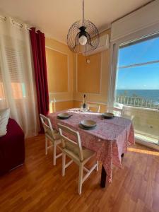 a dining room with a table and chairs and a window at Alloggio turistico fronte mare con vista da sogno in Ladispoli