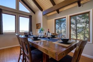 a dining room with a wooden table and some windows at Lake View Cabin Incredible Panoramic Views, Spa in Sevierville