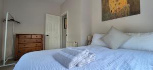 a bedroom with a white bed and a painting on the wall at Cottage Corner NI in Newtownards