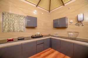 a kitchen with gray cabinets and a counter top at Spring Fields in Coimbatore
