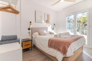a white bedroom with a bed and a window at RentitSpain - Playa Granada - Apartamentos TRM Aguacate Relax entre Mar, Golf y Montaña in Motril +148 photos