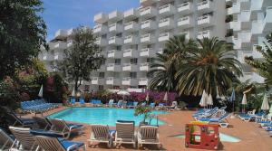 a hotel with chairs and a pool and a building at Sea views Estudio Ponderosa near the beach in Costa de Adeje