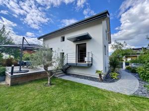 a white house with a balcony and a yard at Maison au calme et en ville in Meythet