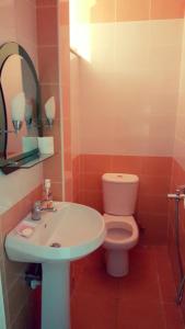 a bathroom with a white toilet and a sink at Apartment Angel in Sarandë