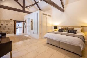 une chambre avec un grand lit et une table dans l'établissement The Dovecote 3-Bed Cottage Rowden Manor, à Chippenham